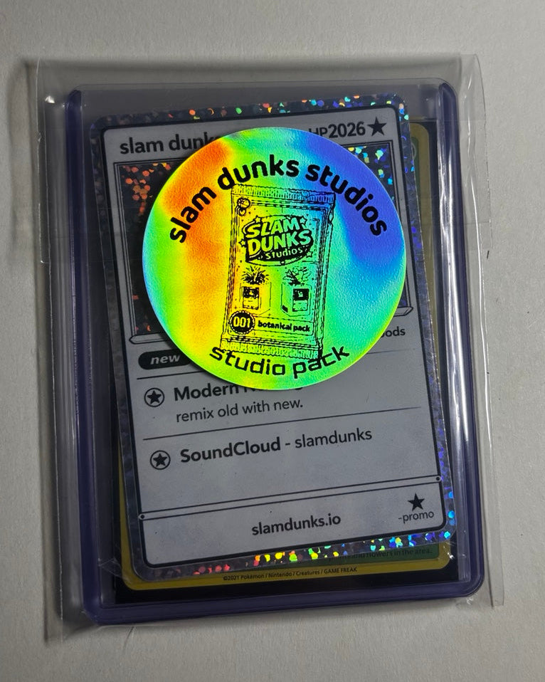 Studio Pack 001 close-up with holographic Slam Dunks Studios sticker and sleeved cards